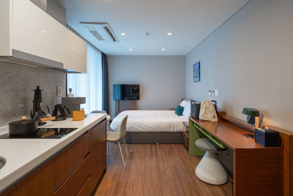 A modern hotel room with a kitchenette, a bed, a desk, and a TV. - Urbanstay Haeundae Station (Busan)