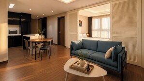 Una sala moderna con sofá, mesa de centro, comedor y cocina.