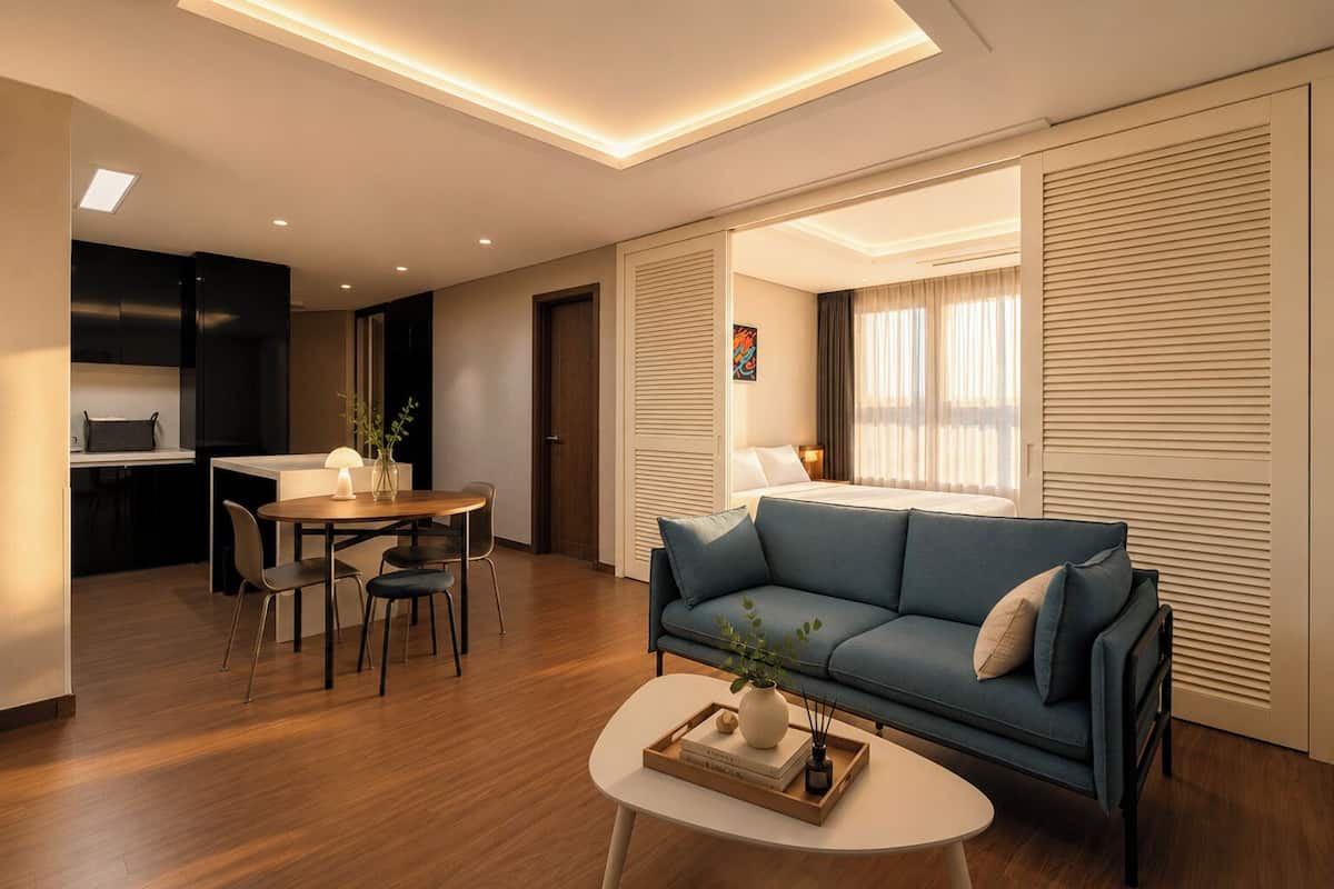 Una sala moderna con sofá, mesa de centro, comedor y cocina.