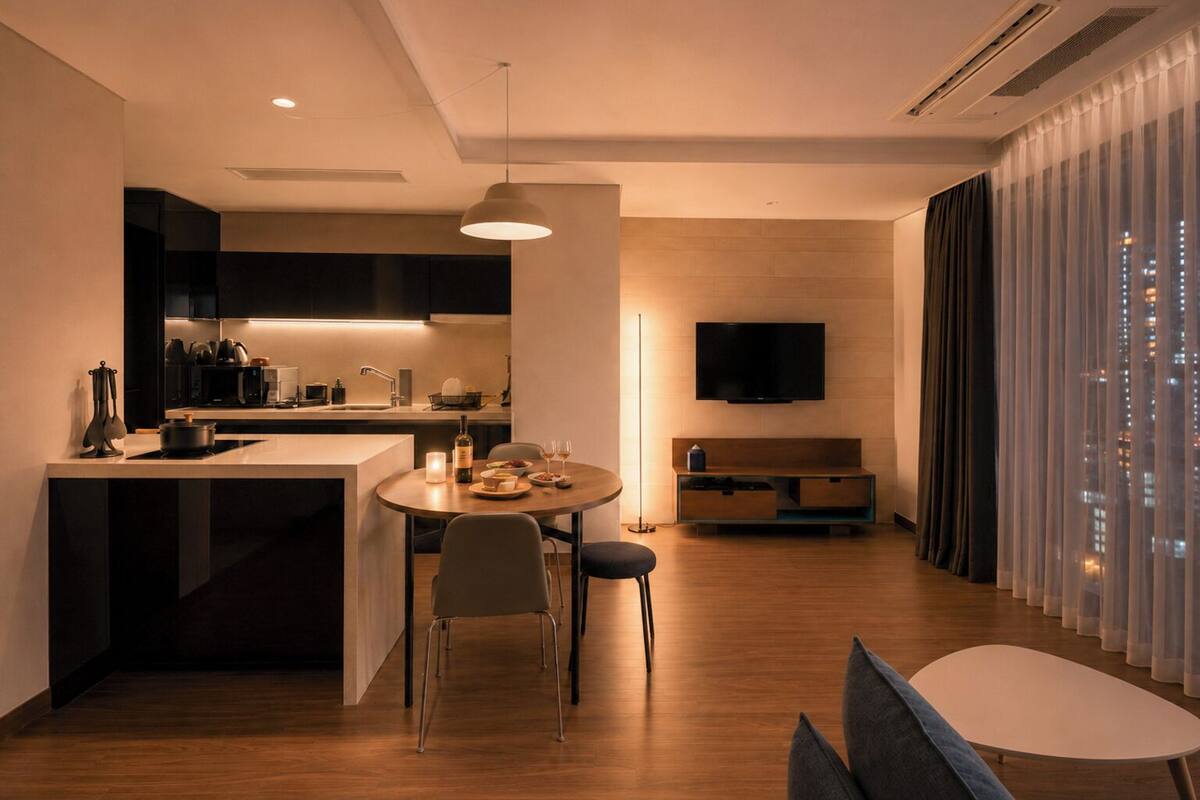 Un espacio habitable moderno con cocina, comedor y televisor montado en la pared.