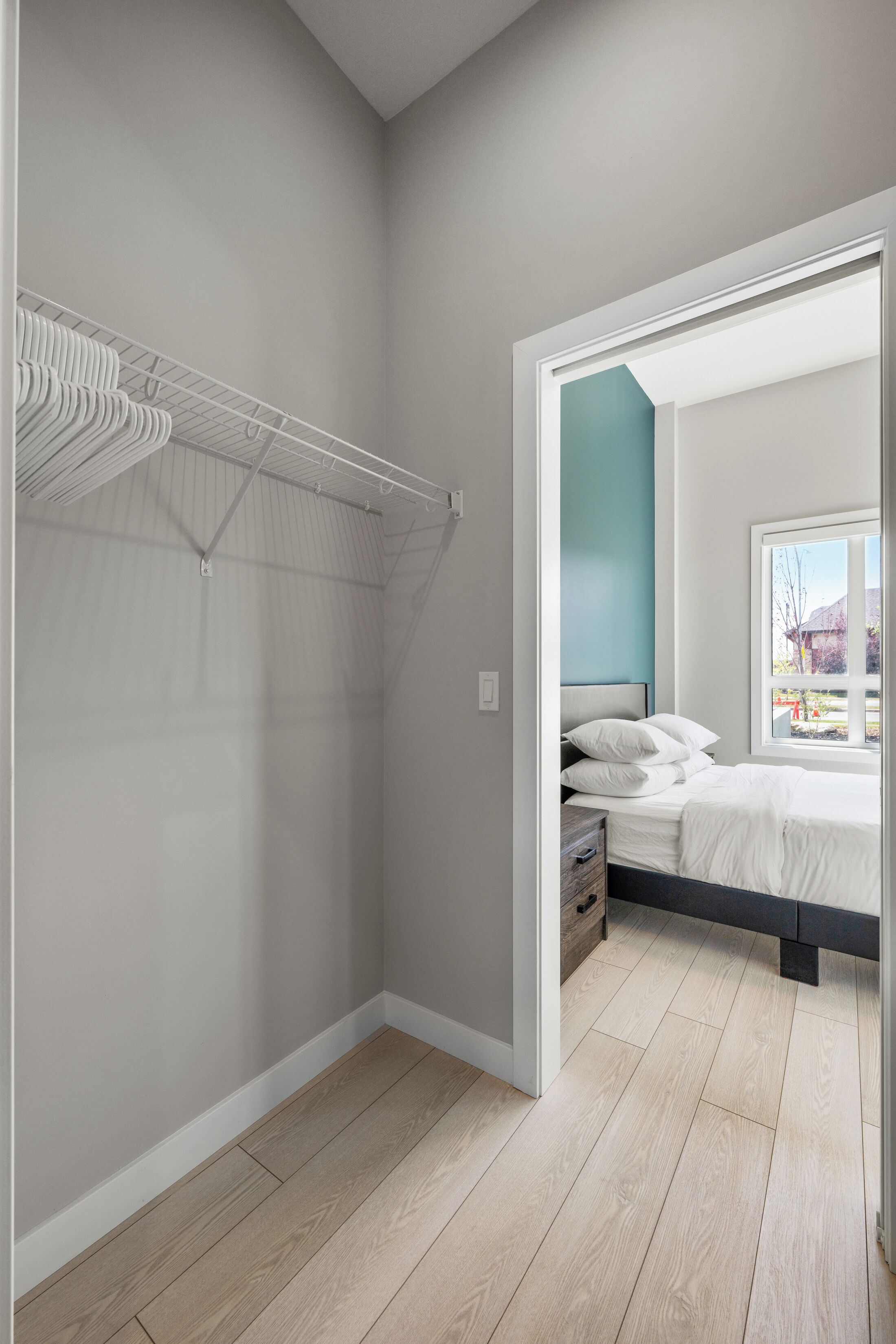 Ein Schlafzimmer mit Bett, begehbarer Kleiderschrank und Fenster mit Aussicht.