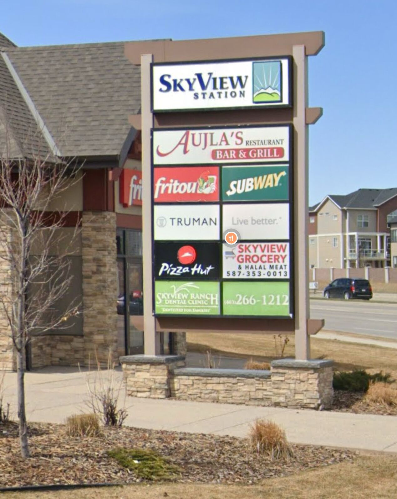 A signboard with various business names and contact numbers.
