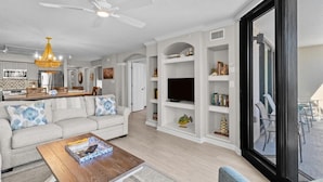 A modern living room with a sofa, coffee table, and built-in TV shelf.