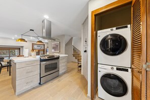 A modern kitchen with a built-in oven, a stainless steel range, and a double sink.