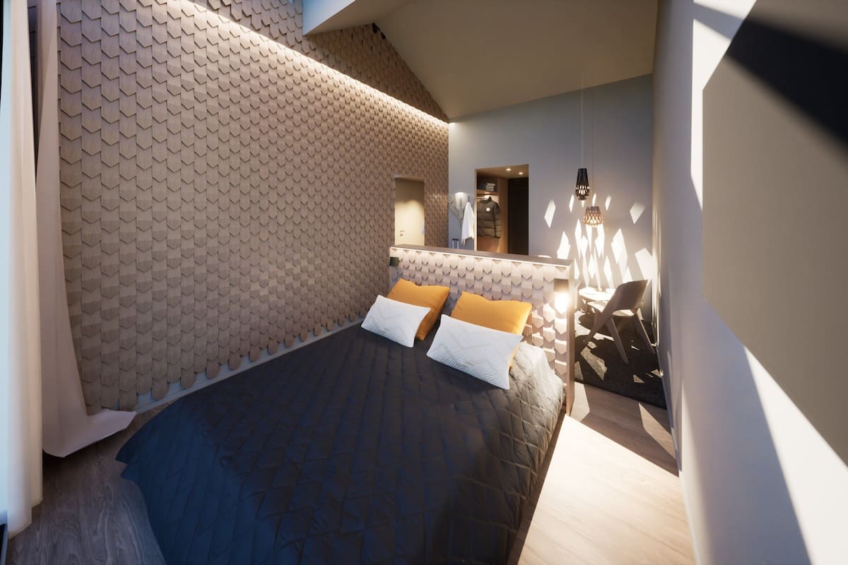Un dormitorio moderno con un papel tapiz de diseño geométrico, una cama con almohadas blancas y anaranjadas, una pequeña mesa redonda y una silla.