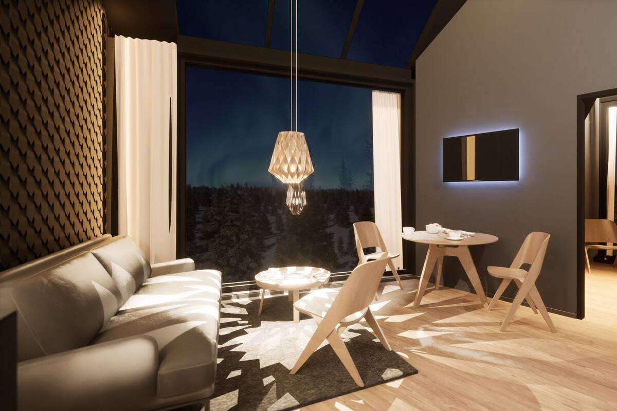 Una sala de estar moderna con un sofá, una mesa de comedor, sillas y un ventanal con vistas a árboles.