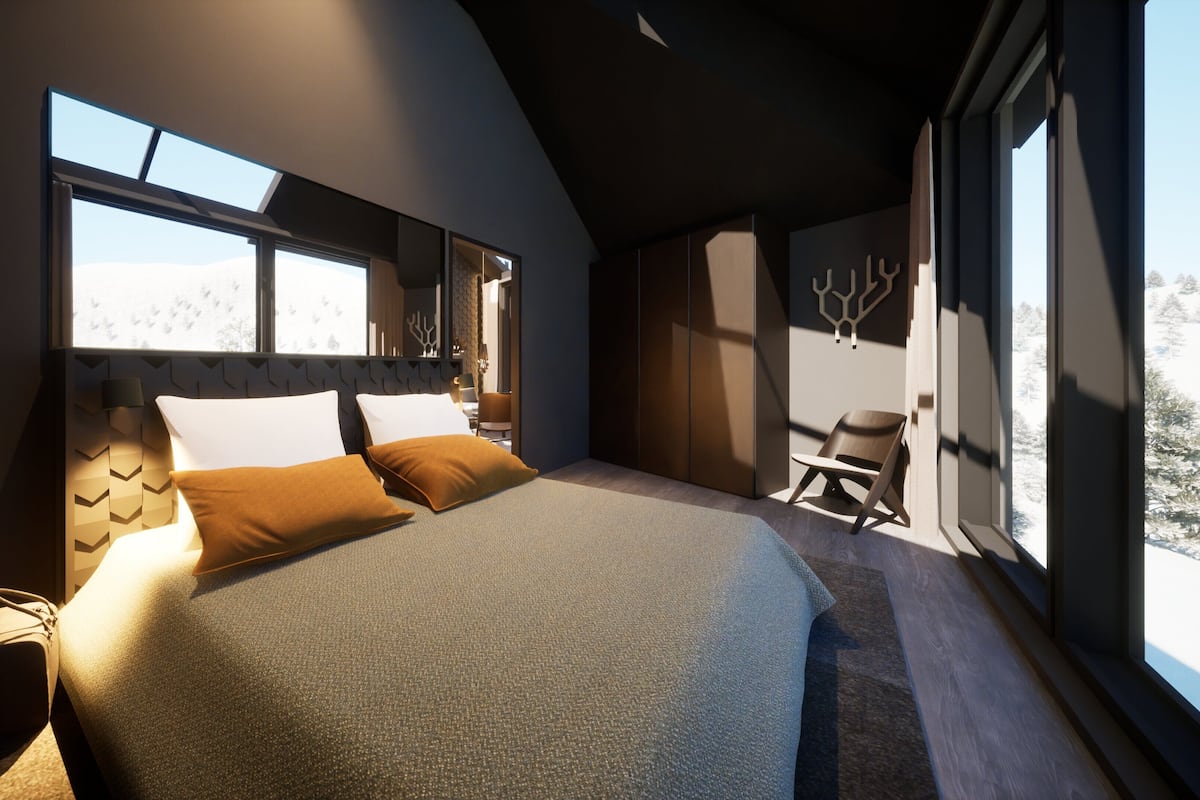 Un dormitorio moderno con una cama grande, una silla y vistas a un paisaje nevado a través de amplios ventanales.
