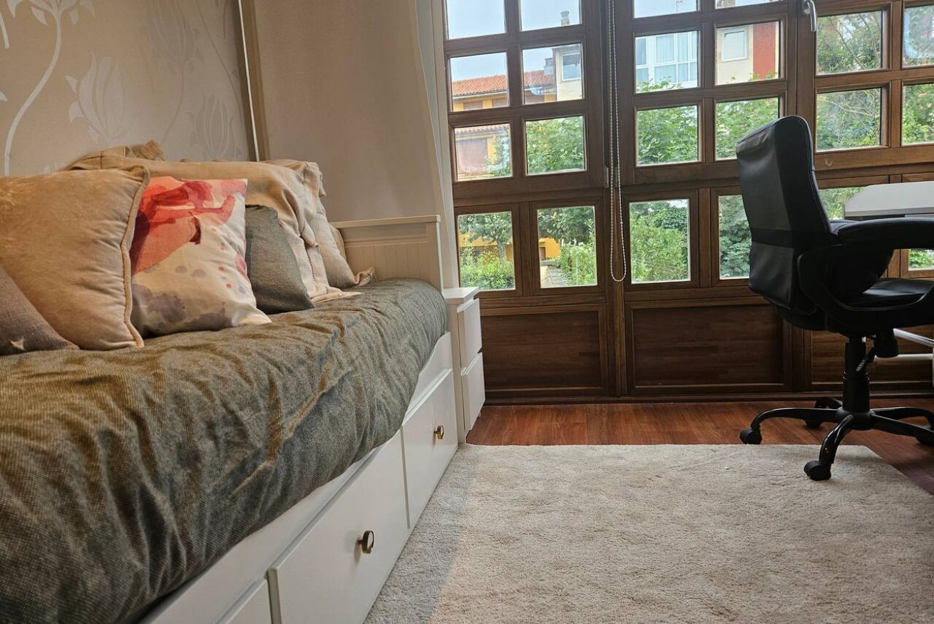 Un dormitorio con cama, escritorio y silla.