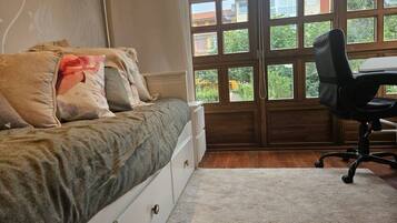 Un dormitorio con cama, escritorio y silla.