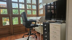 Une pièce comprenant un bureau, une chaise, un téléviseur et un classeur.