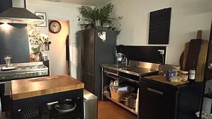 Eine kleine Küche mit Herd, Kühlschrank und einer Essecke.