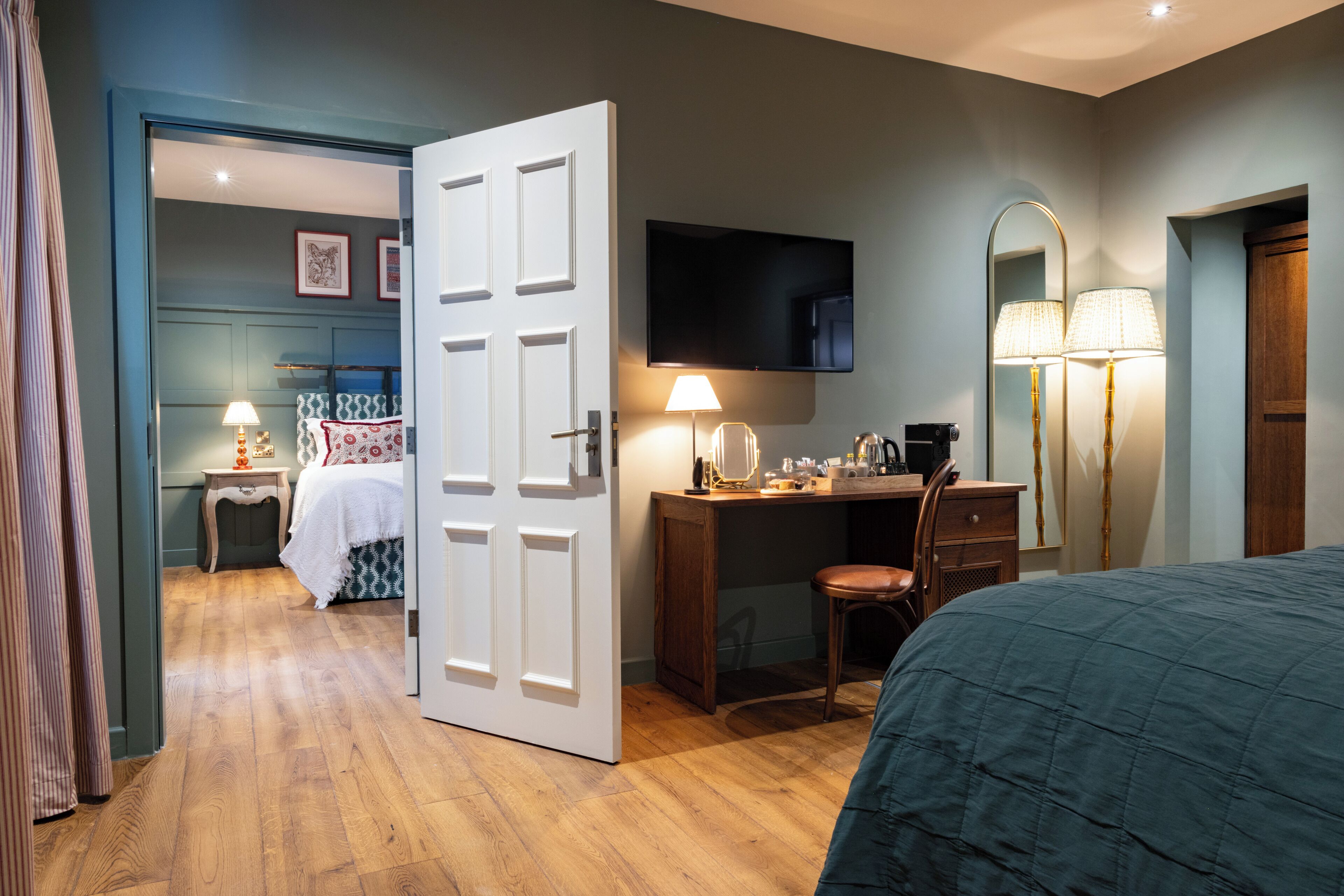 A bedroom with a bed, a desk, a chair, a TV, and a wardrobe.