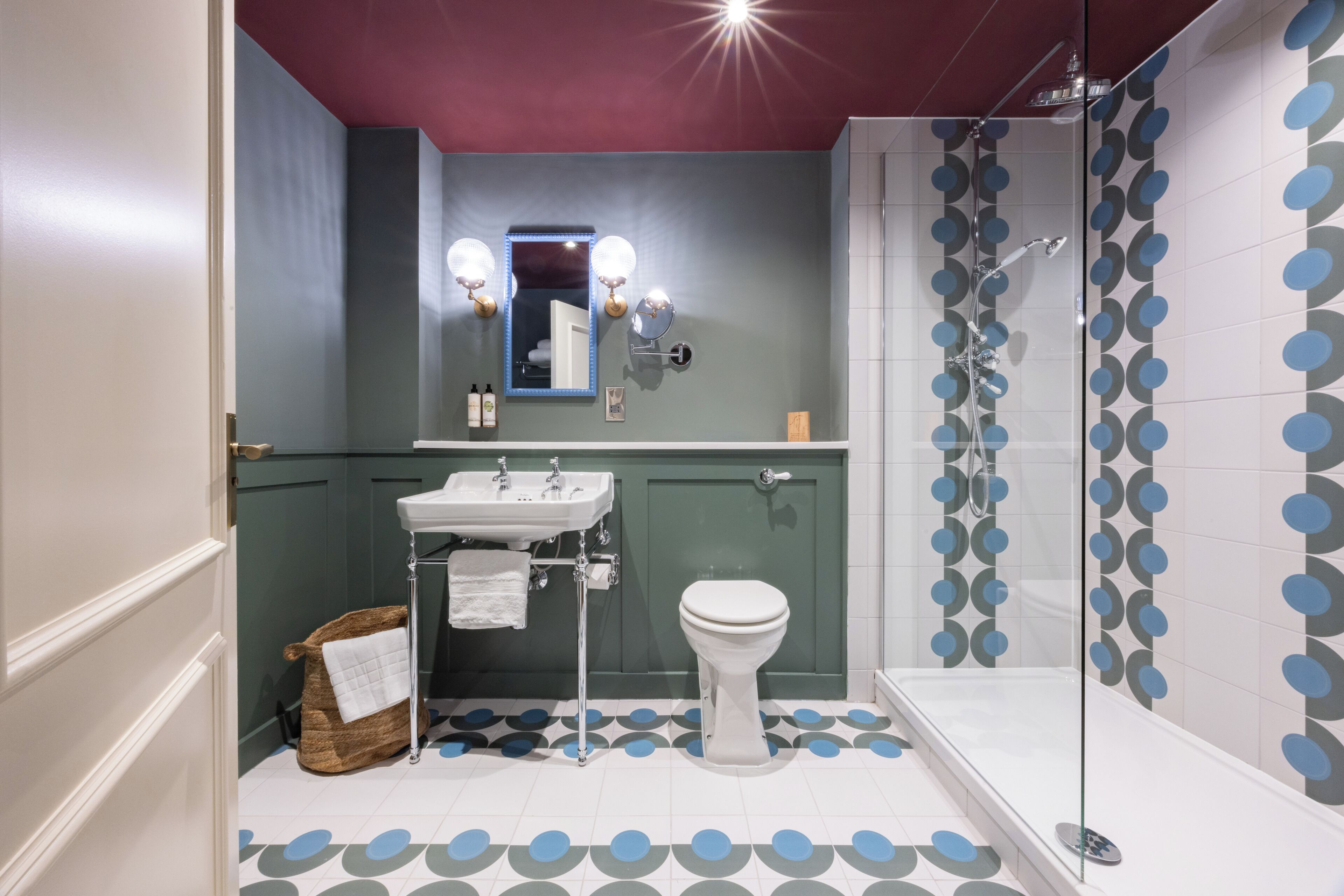 A bathroom with a shower, toilet, sink, and mirror.