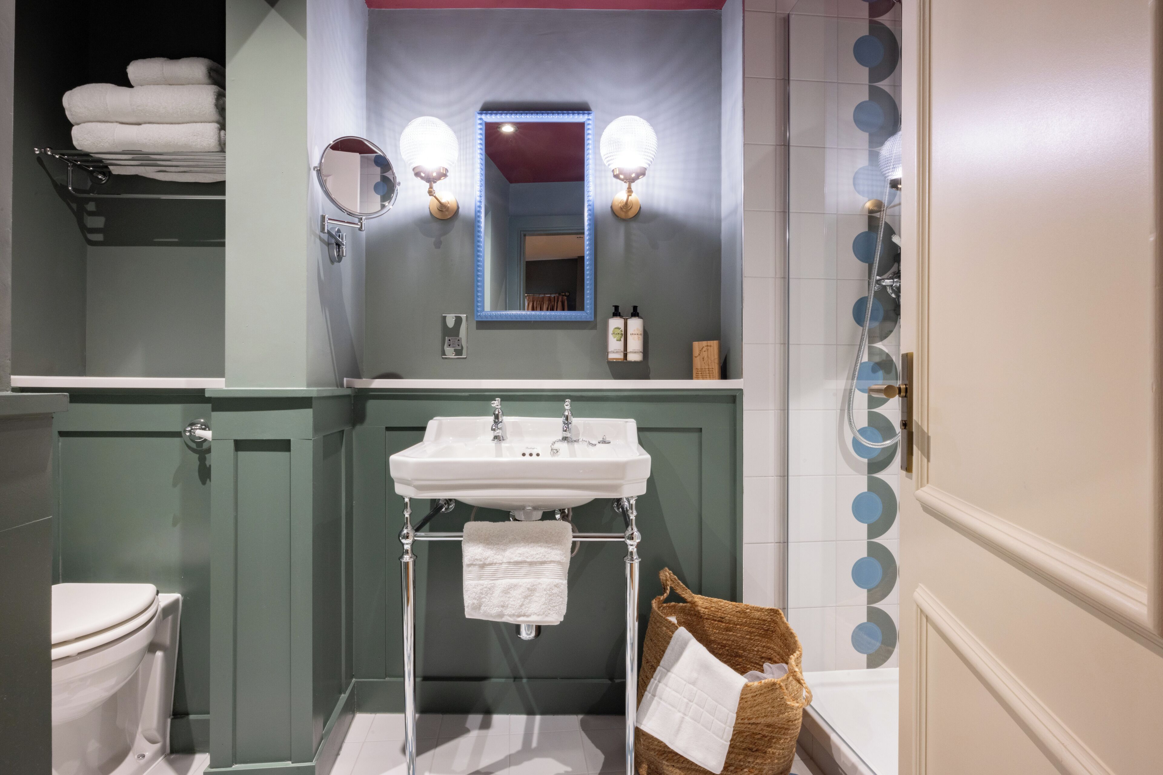 A bathroom with a white sink, a mirror, and a towel rack.