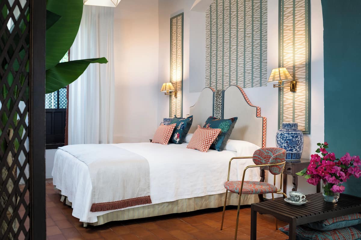 Une chambre à coucher bien aménagée, avec un grand lit, une chaise, une table et des panneaux décoratifs sur les murs.