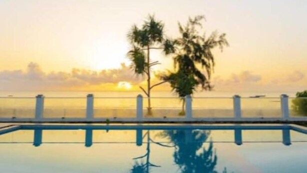 A serene pool with a clear reflection of trees and a sunset in the background. - Muteithia Mbaabu (Nairobi)