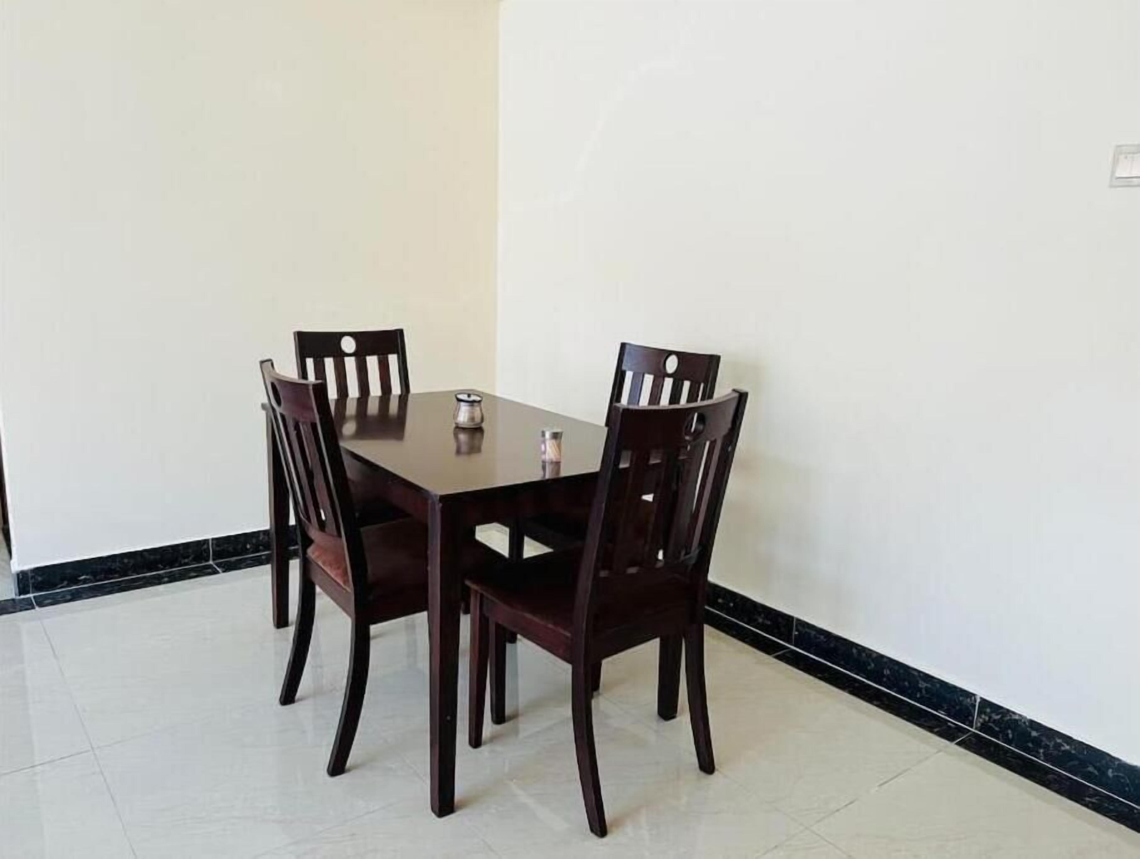 Un comedor con una mesa rectangular y cuatro sillas de madera.