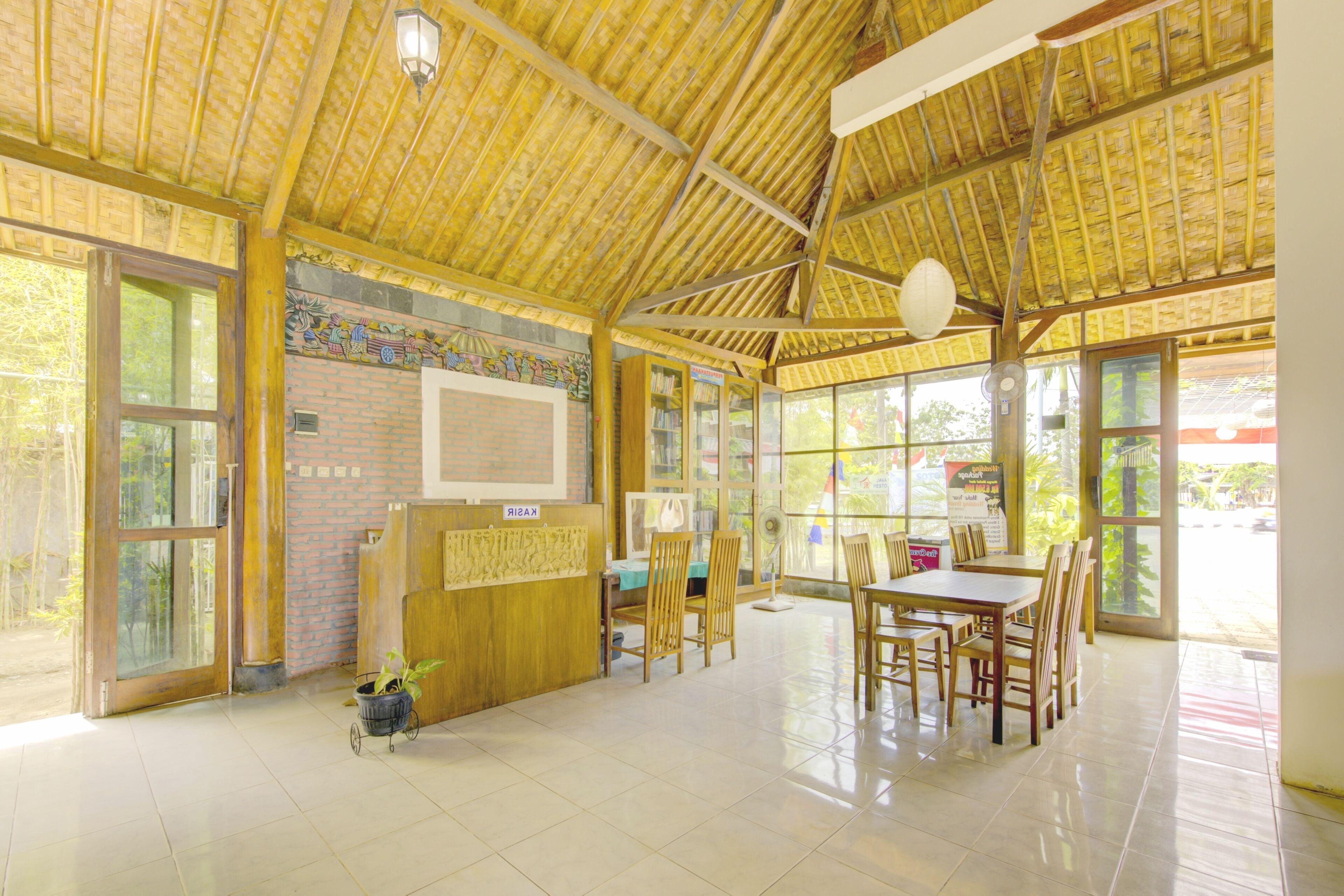 A spacious indoor area with a high ceiling, large windows, and a reception desk.