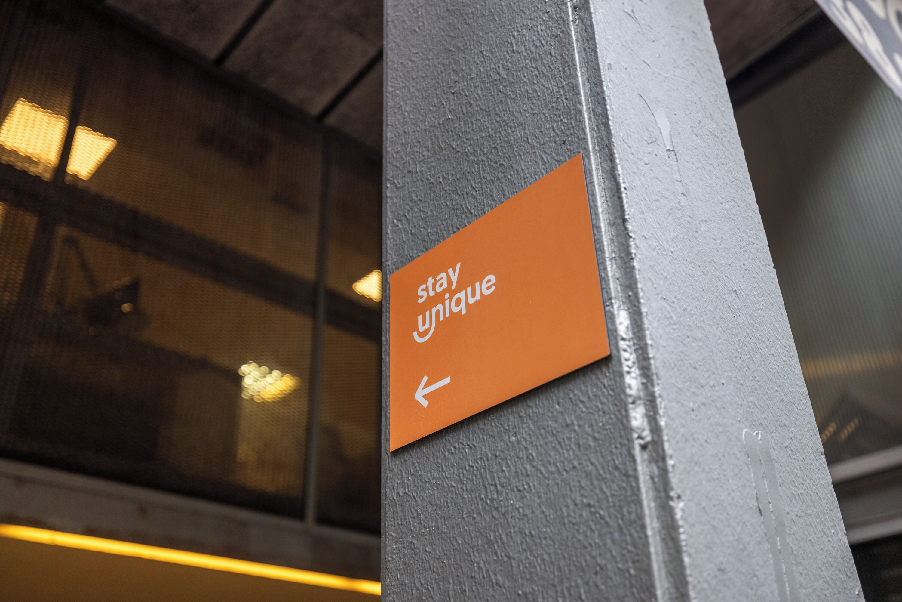 A sign with the text 'stay unique' and an arrow pointing left.