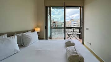 Escritorio, tabla de planchar con plancha y ropa de cama