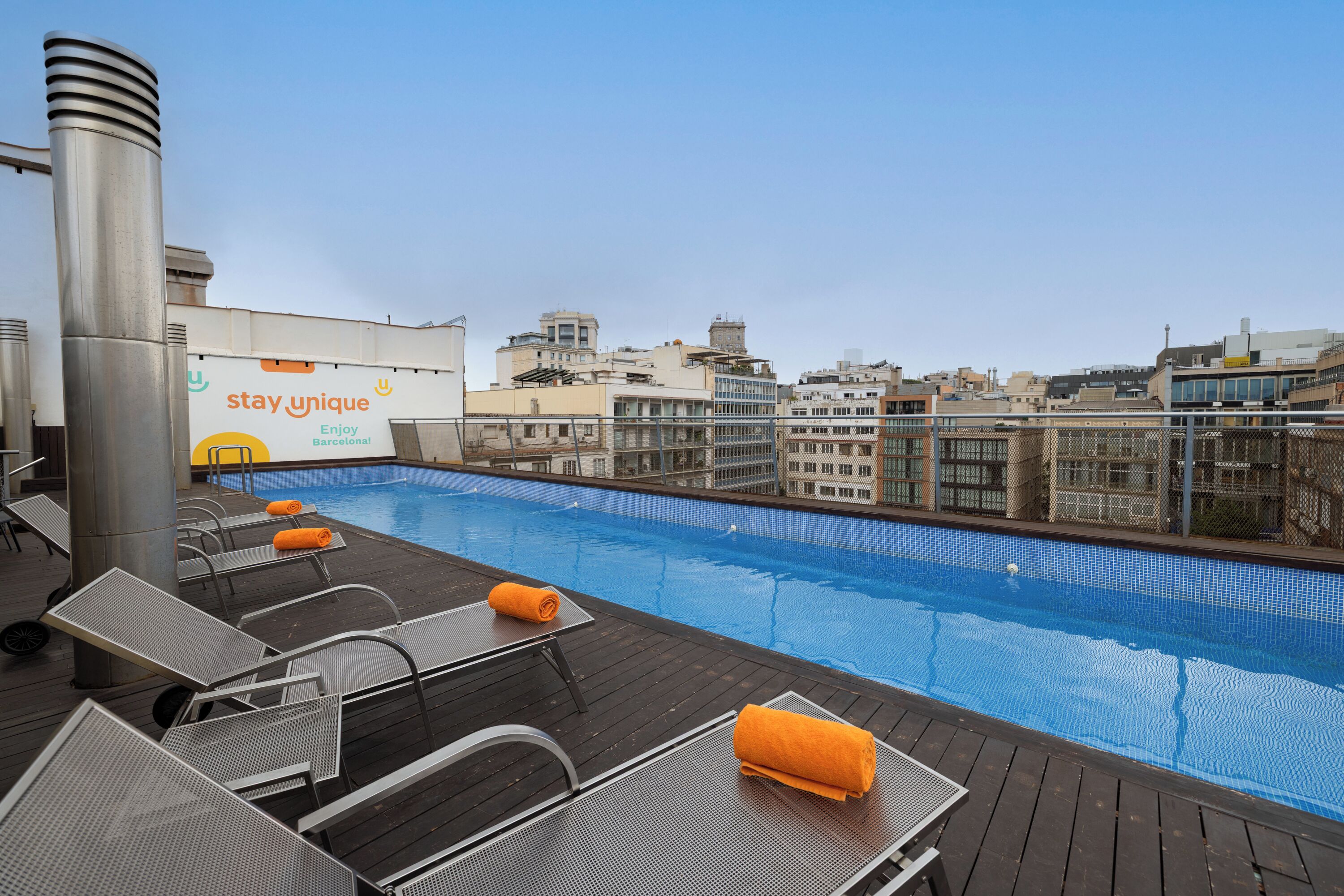 Una piscina al aire libre, sillones reclinables de piscina