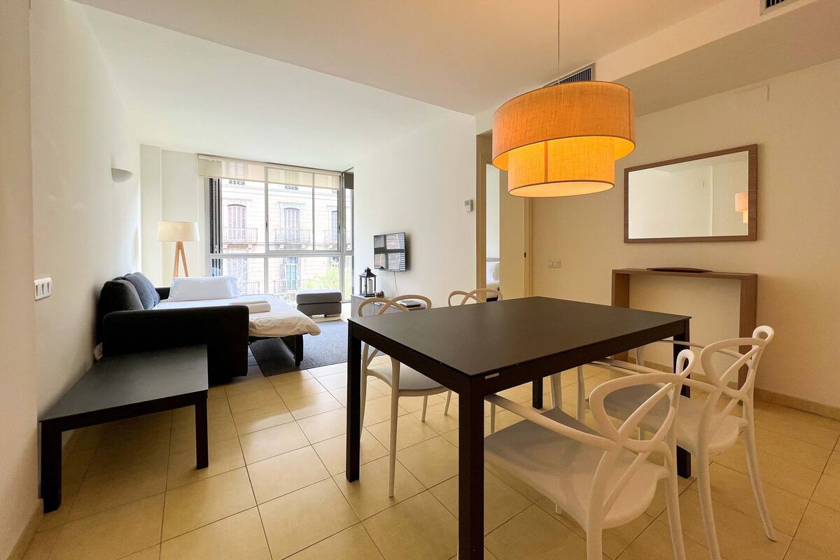 Ein modernes Hotelzimmer mit Essbereich, einer Couch, einem Tisch und Stühlen.