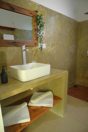 A bathroom with a white sink, wooden vanity, and a mirror. - Holiday Time Bungalows Zanzibar (Matemwe)