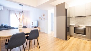 A modern kitchen with a built-in oven and a refrigerator. - Urban Comfort 2 Bdrm Next to Metro (Athens)