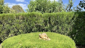 A circular hedge garden with a statue of a lioness in the center. - Sias Cozy House (Sithonia)
