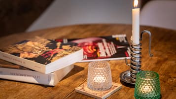 Une table en bois avec une bougie allumée, un livre et un chandelier.