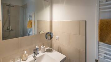 A bathroom with a sink, mirror, and towel rack.