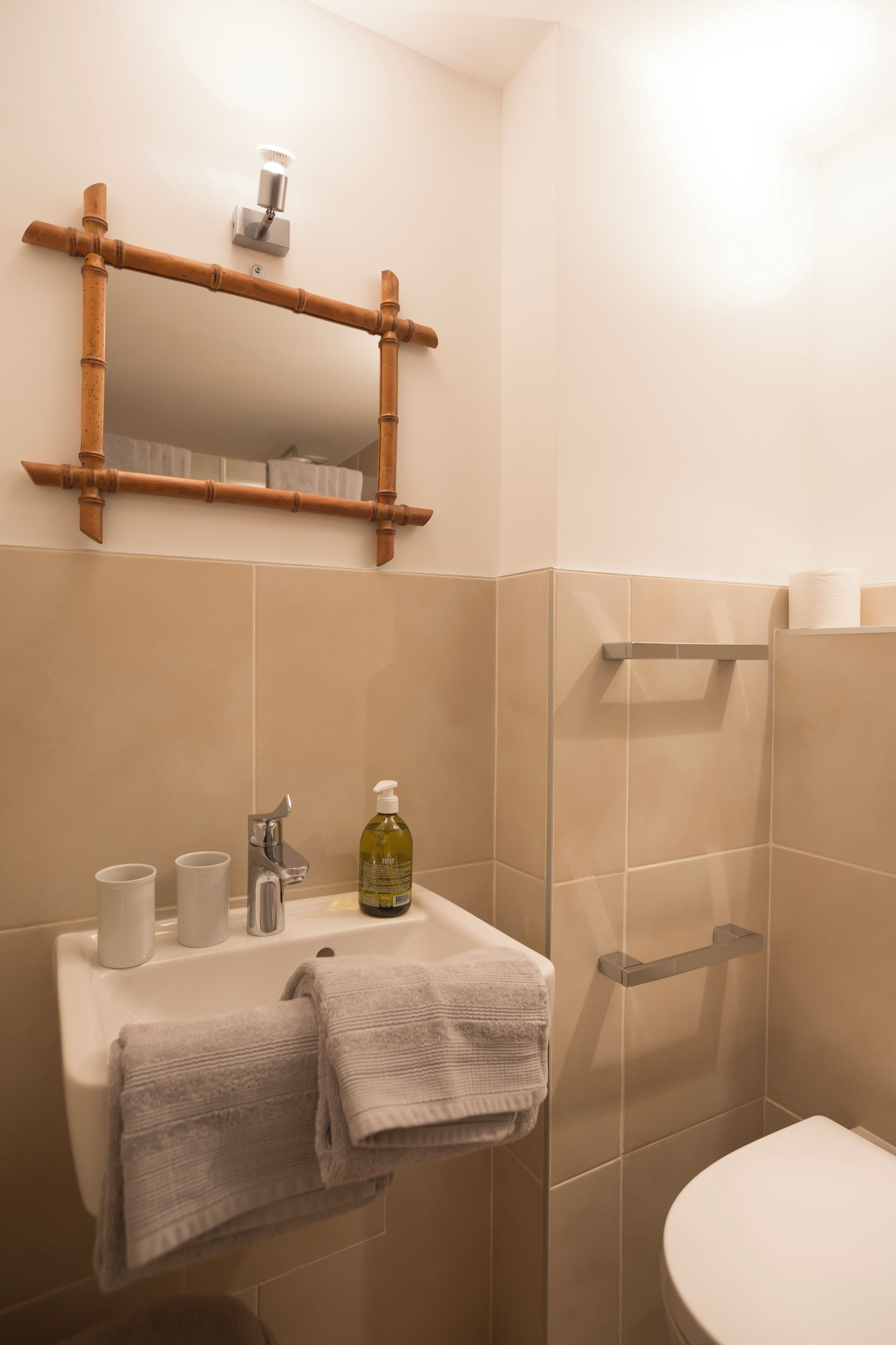 A bathroom with a sink, mirror, and toilet.