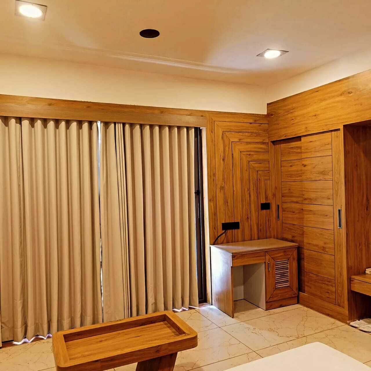 A room with a wooden wardrobe, a small desk, and a wooden bench.