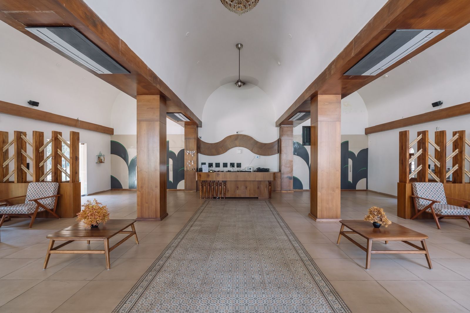 A spacious lobby with wooden beams, a reception desk, and seating areas.