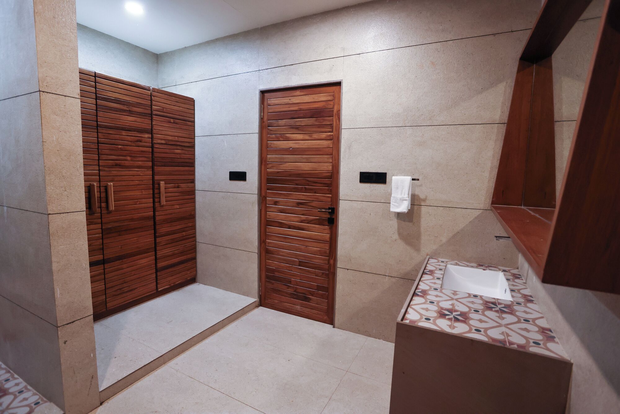 Un baño con armario de madera, lavamanos y espejo.