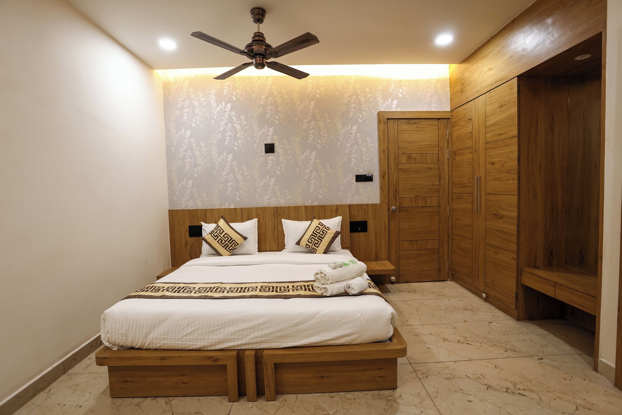 A bedroom with a wooden bed, a ceiling fan, and a wardrobe.