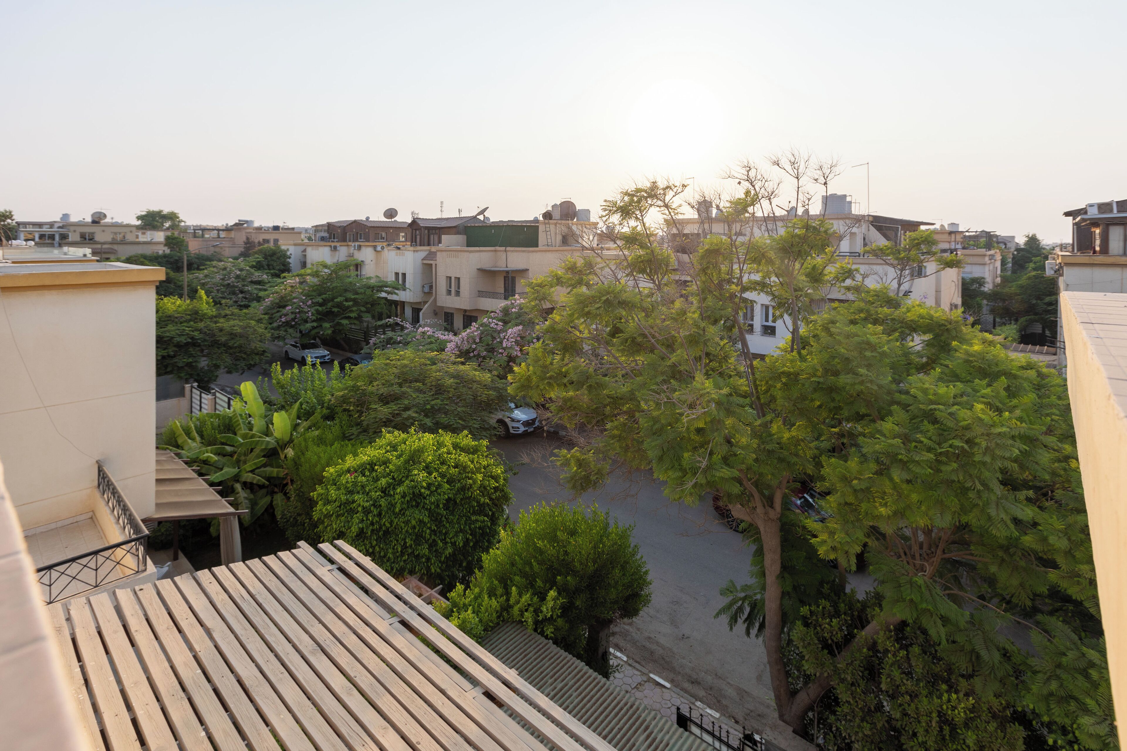 Zona residencial con varios edificios, una calle pavimentada y árboles.