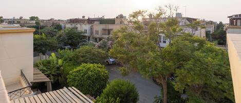 Zona residencial con varios edificios, una calle pavimentada y árboles.