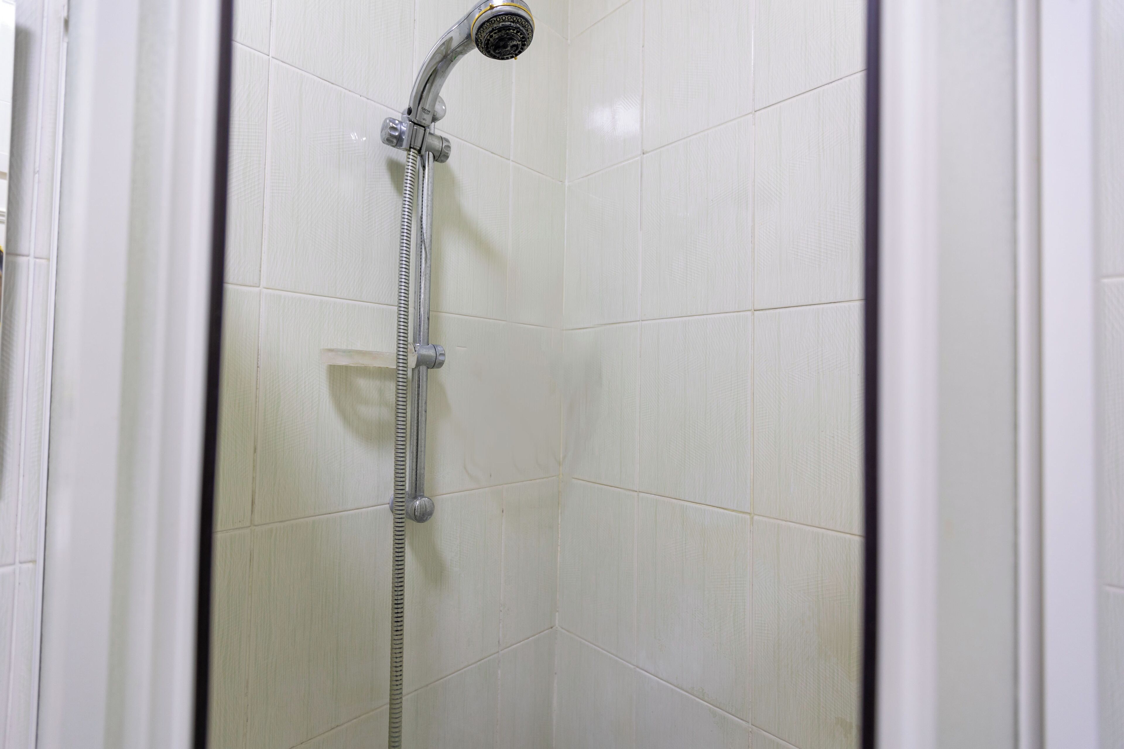 A shower with a handheld showerhead and a flexible hose.