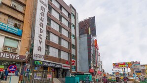 A multi-story hotel with signage for 'MAHADEVA REGENCY' and 'Tenskart.com'. - Hotel Mahadeva Regency (Kanpur)