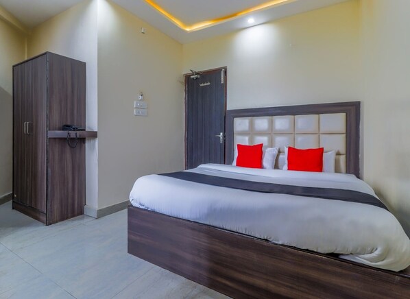 Una habitación de hotel con una cama grande, un armario y una puerta.