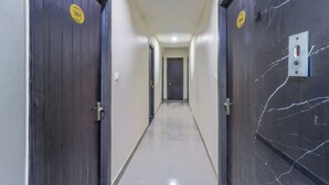 A corridor with two doors, each marked with a number sign. - Hotel Mahadeva Regency (Kanpur)