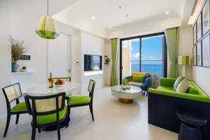 Relax in this serene space with a round table, comfortable sofa, and balcony views of the sea.