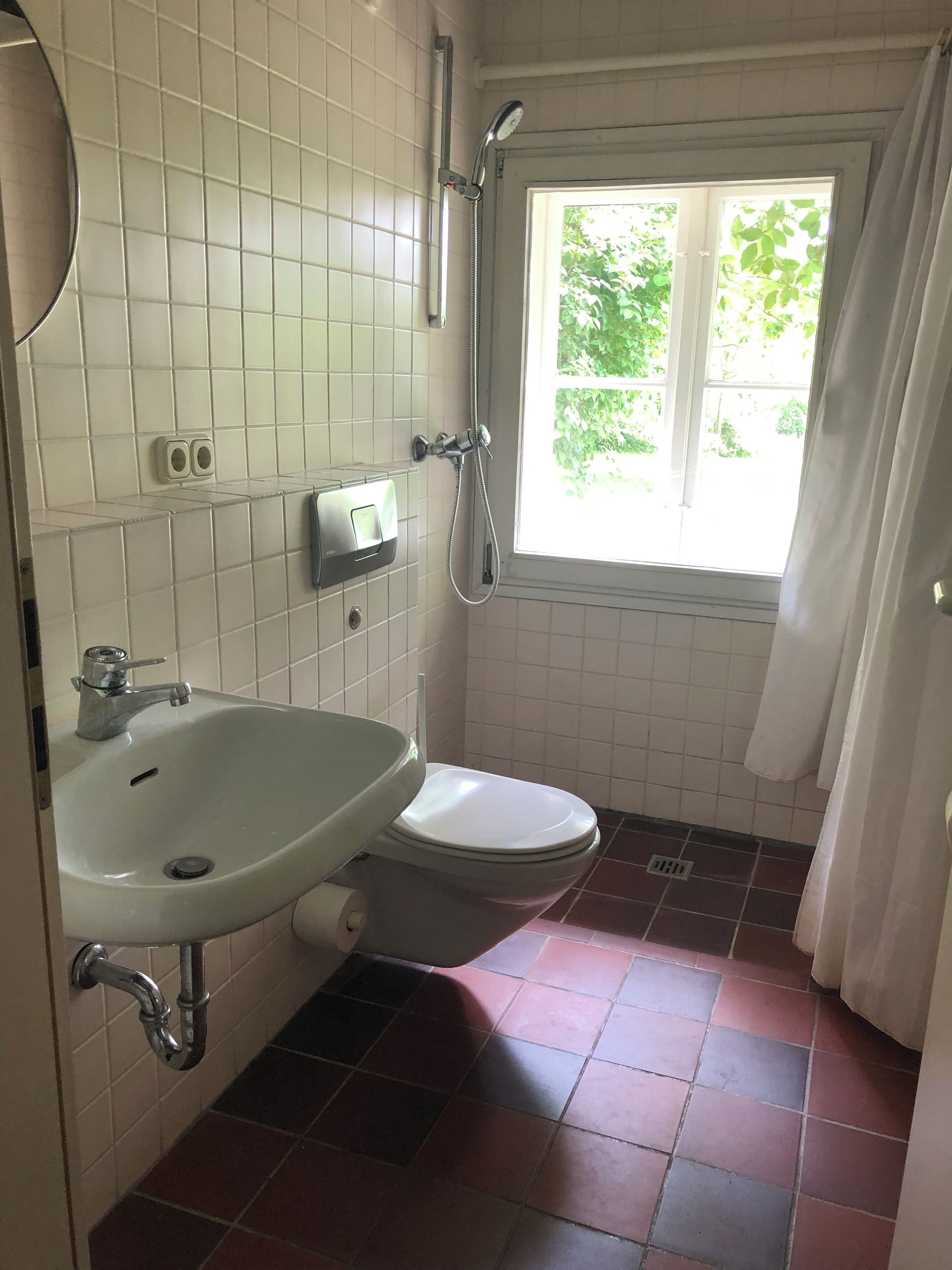 Une salle de bain avec des toilettes, un lavabo et une douche.