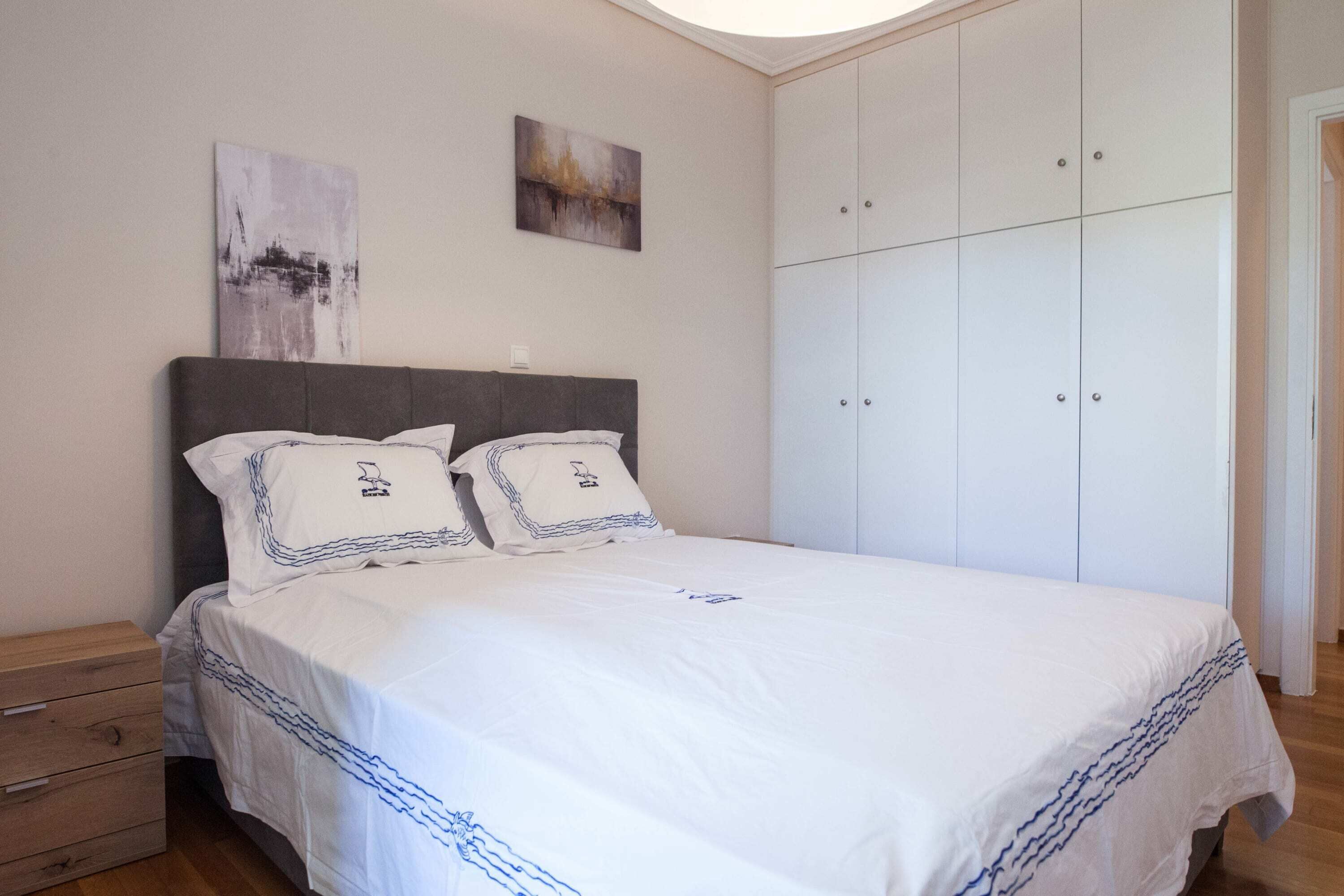 Ein Schlafzimmer mit einem Bett, einem Kleiderschrank und zwei Bildern an der Wand.
