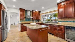 A modern kitchen with granite countertops, stainless steel appliances, and wooden cabinetry.