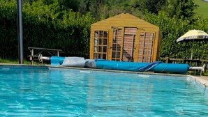 A swimming pool with a wooden structure and a blue pool cover. - River Bliss in Whelspool (Welshpool)
