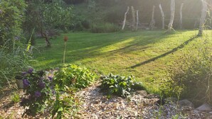 A garden with a variety of plants and a wooden fence. - Ferienwohnung am Neetzetal (Thomasburg)