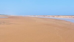 A wide, open sandy beach with a clear blue sky. - Kijani Residences Condos (Malindi)