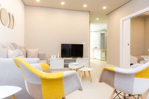 Relax in this stylish living room with a comfortable sofa set, flat-screen TV, and a cozy reading nook.